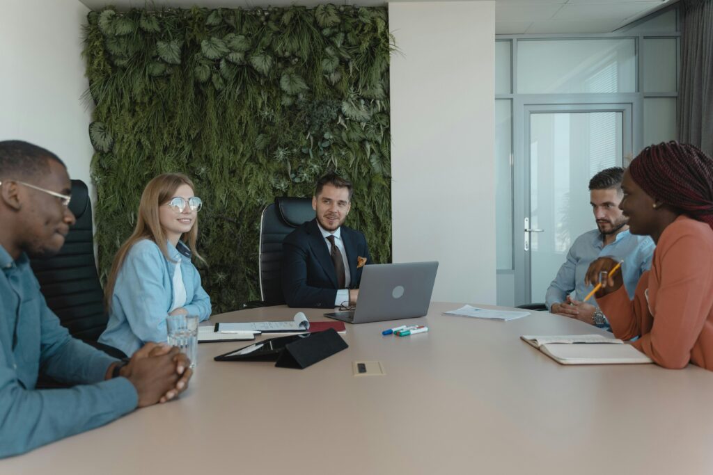 Small, diverse team meets in a modern office featuring a living green wall.