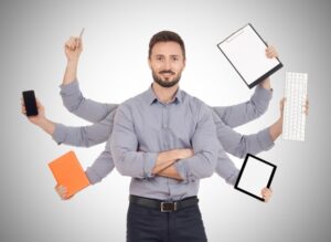 Composite image of a multitasking businessman with six extra arms holding office items.