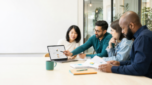 A technical team reviewing work on a laptop in a real workplace, weighing how AI is changing decisions and trust.