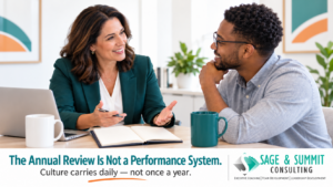 A manager and employee in a construction or industrial office in a real work conversation — daily performance, not annual paperwork.
